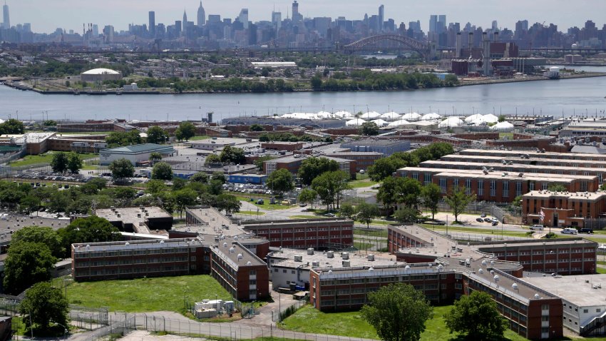 FILE – The Rikers Island jail complex stands in New York with the Manhattan skyline in the background June 20, 2014. (AP Photo/Seth Wenig, File)