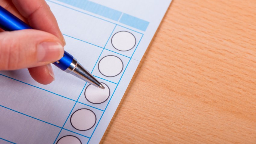 woman making cross on voting ballot