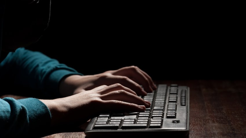 Unknown person hands using a keyboard sends message with intimidating and threatening to the interlocutor