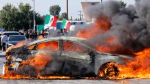 Los Angeles, CA - June 07: A car burns in the middle of the intersection of Atlantic Ave. and E Alondra Blvd. during ICE protests on Saturday, June 7, 2025 in Los Angeles, CA. (Carlin Stiehl / Los Angeles Times via Getty Images)