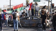 Compton, CA June 7, 2025  Protesters on top of burnt cars in Compton, Calif., Saturday, June 7, 2025, after federal immigration authorities conducted operations. (Gina Ferazzi/Los Angeles Times via Getty Images)