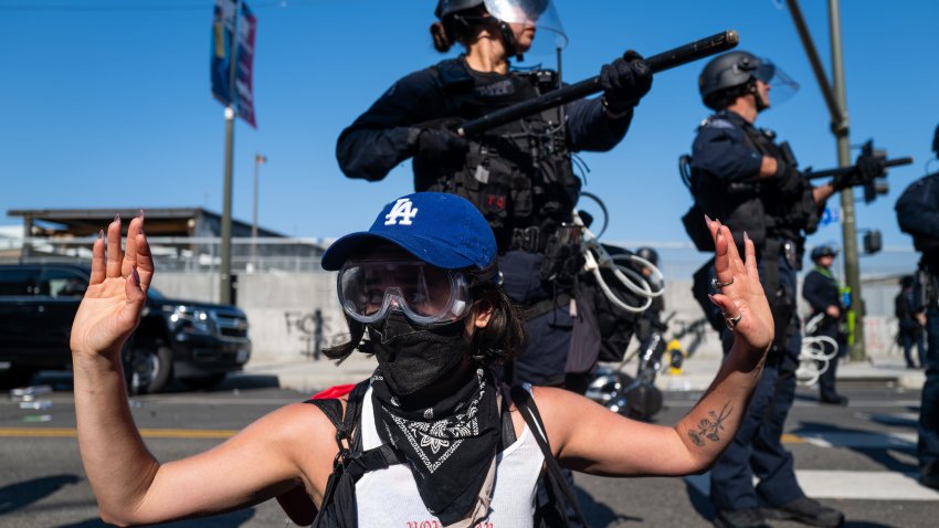 LOS ANGELES, CALIFORNIA – JUNE 08: A protester raises their hands in front of LAPD officers during protests after a series of immigration raids on June 08, 2025 in Los Angeles, California. Tensions in the city remain high after the Trump istration called in the National Guard against the wishes of city leaders. (Photo by Spencer Platt/Getty Images)1