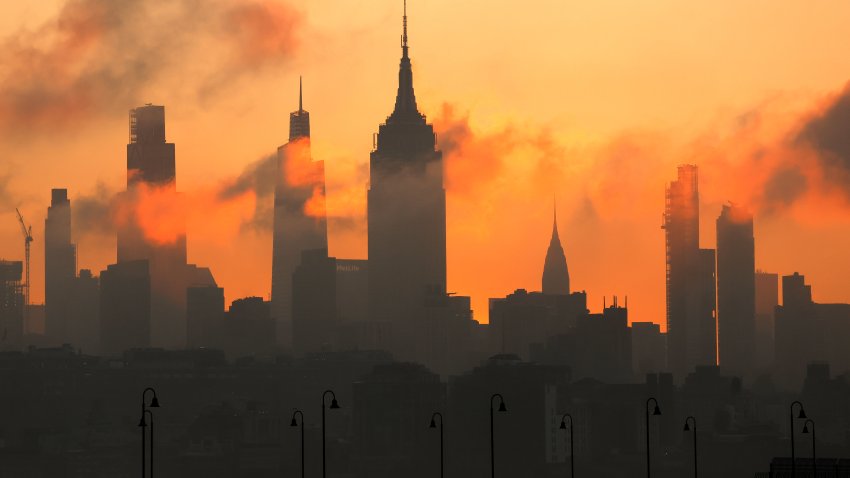 JERSEY CITY, NJ – JUNE 19: The sun rises behind the skyline of midtown Manhattan and the Empire State Building in New York City, a day ahead of the summer solstice and an expected heatwave on June 19, 2025, as seen from Jersey City, New Jersey.  (Photo by Gary Hershorn/Getty Images)