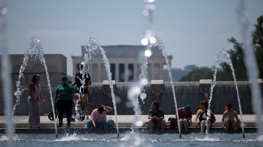 WASHINGTON, DC – JUNE 24: Visitors dip their feet into the World War II Memorial pool on the National Mall on June 24, 2025 in Washington, DC. Temperatures soared this week as the National Weather Service issued an Extreme Heat Warning in Washington, DC from 11 a.m. to 9 p.m on June 23 and 24th, with temperatures hitting a heat index of up to 110 degrees. (Photo by Kayla Bartkowski/Getty Images)