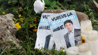Panfletos con la imagen del senador colombiano Miguel Uribe Turbay, junto a velas y flores, colocadas junto al lugar en el que fue disparado durante un mitin político en Bogotá, Colombia, el lunes 9 de junio de 2025.