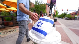 Un transeúnte toca una bandera israelí colocada en Pearl Street Mall cerca de los tribunales en Boulder, Colorado, el 2 de junio del 2025.