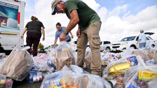 Voluntarios organizan bolsas de alimentos durante una distribución gratuita de comida para beneficiarios del Programa de Asistencia Nutricional Suplementaria (SNAP), organizada por la Oficina del Sheriff del Condado de Volusia y la Federación Judía en el Daytona International Speedway de Daytona Beach, Florida, el 9 de noviembre de 2025.
