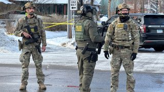 Agentes federales cerca de una barrera vial tras el reporte de un tiroteo en Minneapolis el 7 de enero del 2026.