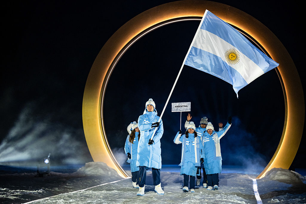 Franco Dal Farra, del equipo de Argentina, y otros miembros del equipo entran al estadio durante la ceremonia de inauguración de los Juegos Olímpicos de Invierno Milano Cortina 2026 en el estadio de saltos de esquí de Predazzo, el 6 de febrero de 2026, en Val di Fiemme, Italia. (Foto de Tom Weller/Getty Images)