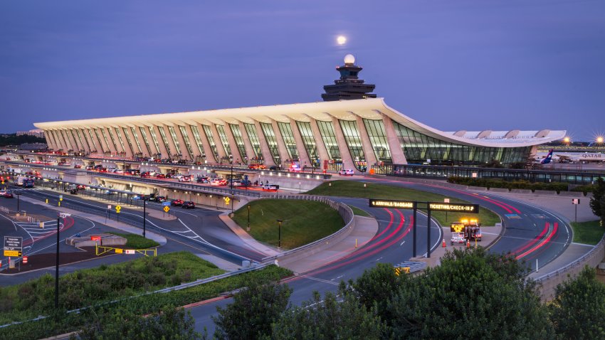 DULLES, VA – MAY 11: Traffic flows past the main passenger terminal at Washington Dulles International Airport at dusk on May 11, 2025, in Dulles, VA. The full moon can be seen above the air traffic control tower. (Photo by J. David Ake/Getty Images)