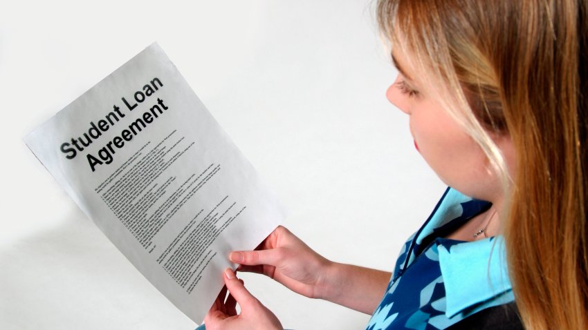 Young Woman Reads Student Loan Agreement . (Photo by: Universal Education/Universal Images Group via Getty Images)