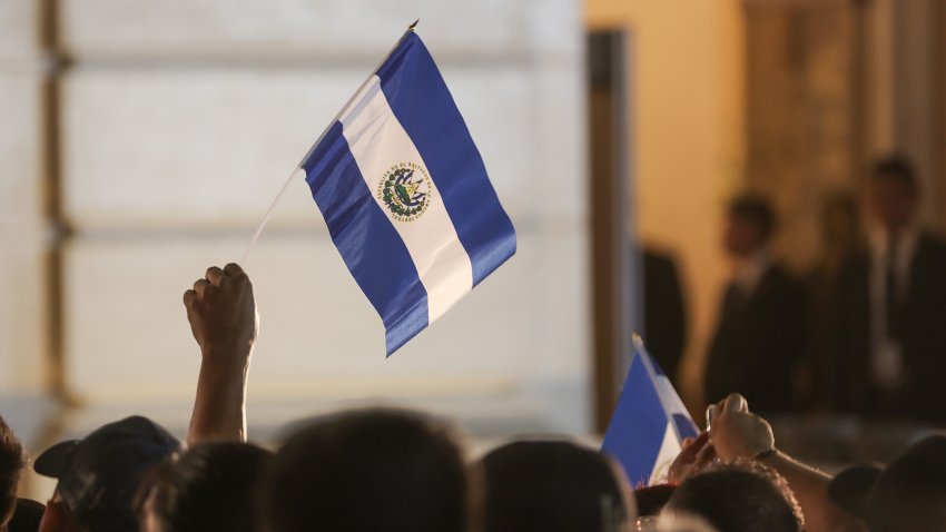 People wave an El Salvador flag.