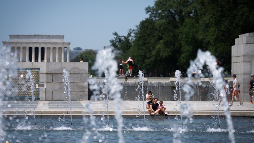 WASHINGTON,DC – JUNE 22: Tourists stop at The World War II Memorial to dip their feet in the fountain to cool off. The temperature soared to 96 degrees on Sunday, June 22, 2025 in Washington, DC. An Extreme Heat Watch goes into effect on Monday. Despite the hot weather, people came to The National Mall to see the monuments. (Photo by Sarah L. Voisin/The Washington Post via Getty Images)