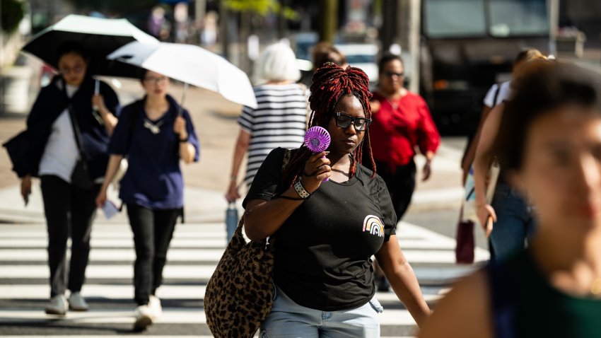Pedestrians carry umbrellas to shield themselves from the sun during high temperatures in Washington, DC, US, on Wednesday, July 1, 2026. The Trump administration has declared a power emergency for the nation’s largest energy grid in advance of a dangerous heat wave that threatens to strain electricity infrastructure. Photographer: Graeme Sloan/Bloomberg via Getty Images