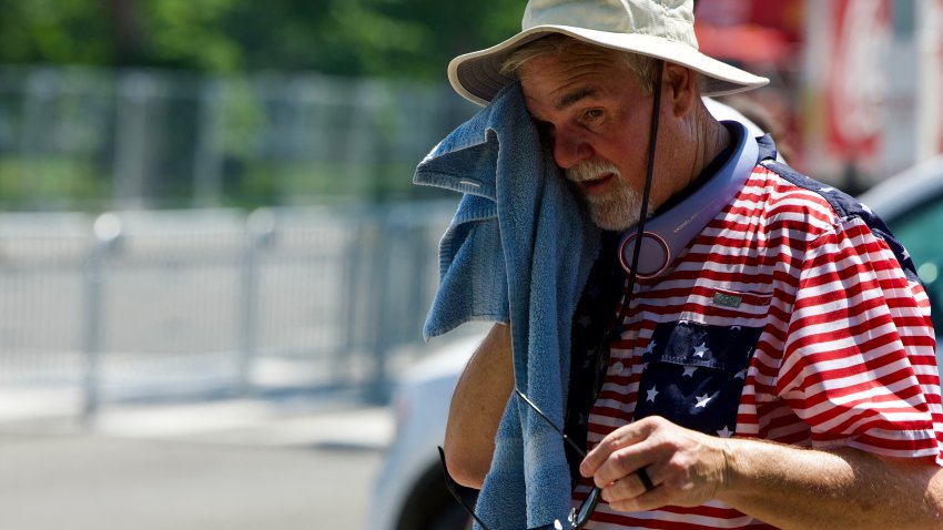 A man wipes himself off as people cope with extreme heat along the National Mall in Washington, DC, on July 3, 2026, as high temperatures grip the US capital ahead of Independence Day celebrations. Blistering temperatures and humidity has gripped swaths of the United States this week, with more to come for the densely populated East Coast as the nation co-hosts the World Cup and prepares to celebrate its 250th birthday on July 4. The heat wave that has been broiling the Midwest is intensifying in the Northeast, with temperatures surpassing 100F (38C) in cities including New York, Philadelphia and Washington. (Photo by Amid FARAHI / AFP via Getty Images)