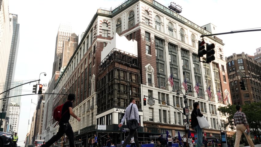 People walk across 34th Street in front of the Macy’s Herald Square store after Macy’s red shopping bag sign, which had been up for over 60 years, was removed over the weekend on July 27, 2026, in New York City. (Photo by Gary Hershorn/Getty Images)