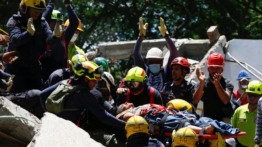 Integrantes del cuerpo de Bomberos de Cali rescatan a Diana Troncoso, de 31 años, quien permaneció atrapada entre los escombros de un edificio colapsado en el barrio Torres del Limonar, tras el terremoto de magnitud 7,4, este martes en Cali (Colombia). EFE/ Ernesto Guzmán