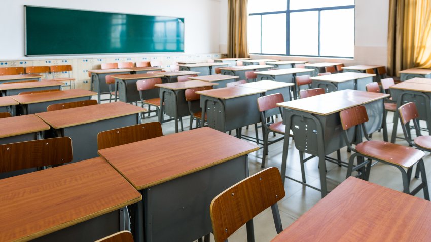 Empty classroom with desks, chairs and chalkboard