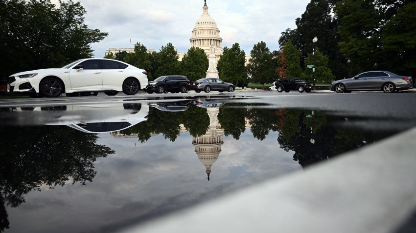 The US Capitol is reflected in a rainwater puddle in Washington, DC, on July 28, 2026. (Photo by Brendan SMIALOWSKI / AFP via Getty Images)