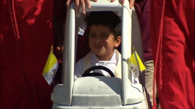 Niños recrean la caravana papal